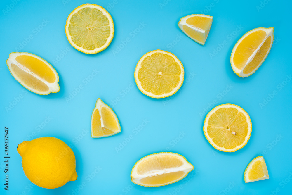 Variety of fresh ripe lemon slices on blue background top view. 