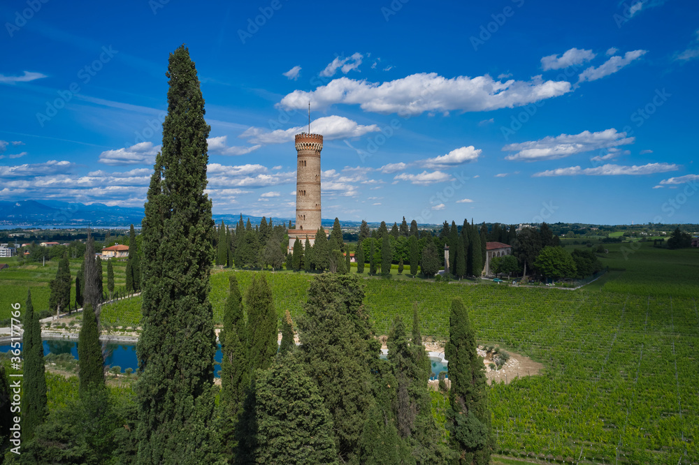 Tower of San Martino della Battaglia Italy. Cumulus clouds in the background of blue sky, Lake Garda. Vineyard plantation at high altitude