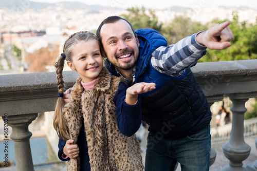cheerful father and daughter pointing at sight during sightseeing tour outdoors photo
