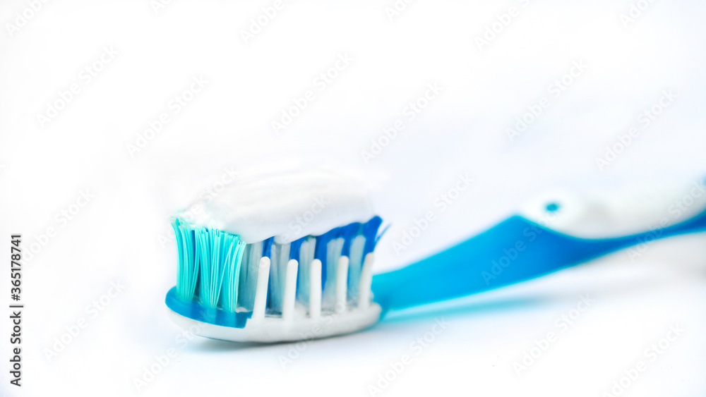 toothbrush on a white background close-up. white toothpaste on a blue toothbrush. the concept of clean teeth and oral cavity. toothbrush on a white background close-up. white toothpaste on a blue toothbrush. the concept of clean teeth and oral cavity.