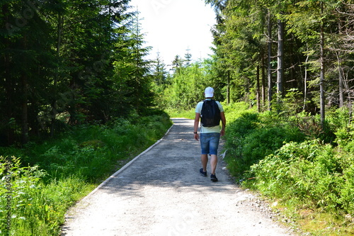 An unidentified man hiking through the mountain green trail to the Rusinowa glade (Rusinowa Polana) on Tatra mountains, Poland