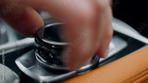 Closeup man hand using control knob at car. Hand touching knob on console at car © stockbusters