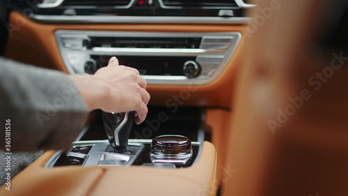 Woman hand touching automatic gear shift. Female driver using control knob