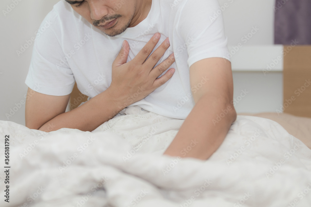 Asian middle aged men have chest pain while lying on the bed Asian middle aged men have chest pain while lying on the bed