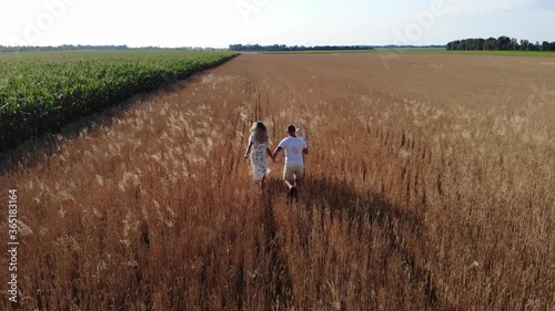 Wallpaper Mural Young parents have fun and run with their baby among wheat field. Torontodigital.ca