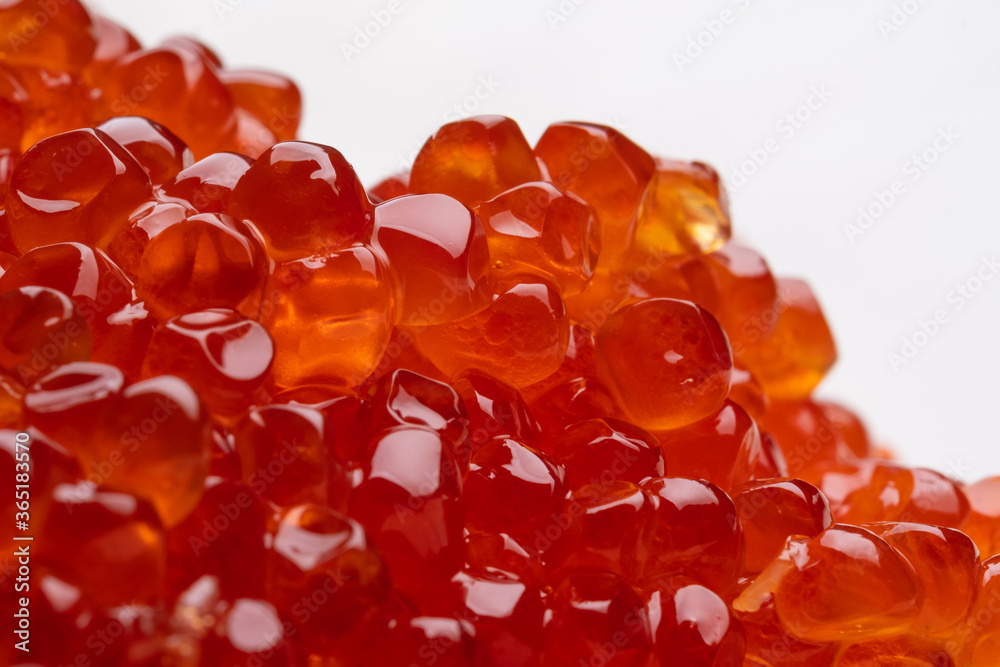 Red caviar isolated on a white background. Gourmet seafood. Macro shot, shallow depth of field