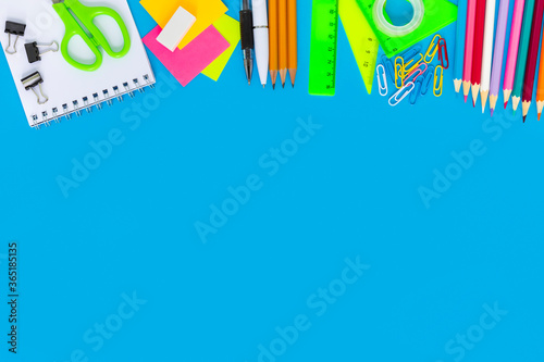 School colorful supplies border on blue, flatlay, top view, back to school, copy space, mockup
