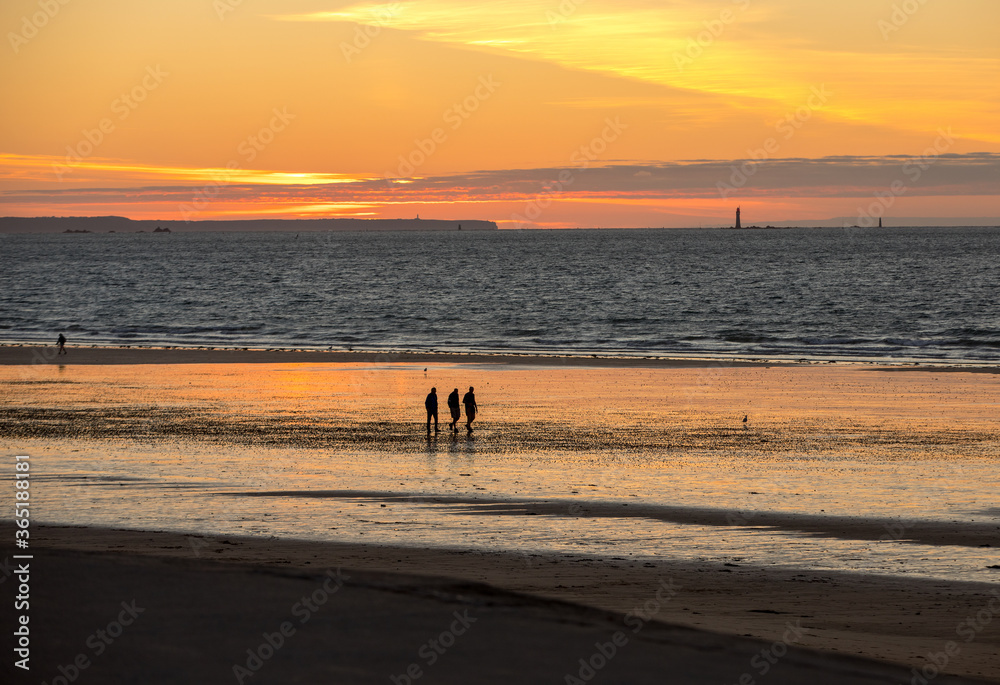  Romantic walk of people before sunset on the picturesque beach of Saint Malo. Brittany, France