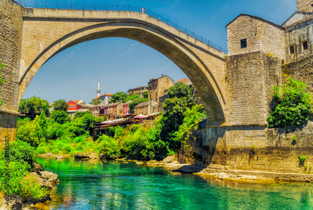 Fototapeta premium A person is standing at famous Old Bridge over river Neretva in Mostar, Bosnia and Herzegovina.