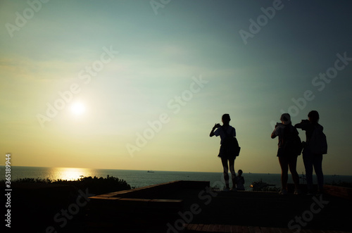 海に沈む夕日を撮る人