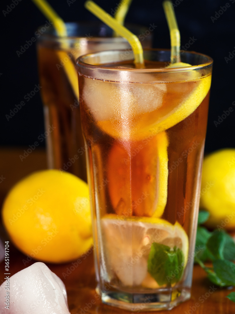 Two glasses of summer ice tea with lemon and mint. Refreshing citrus drink Two glasses of summer ice tea with lemon and mint. Refreshing citrus drink