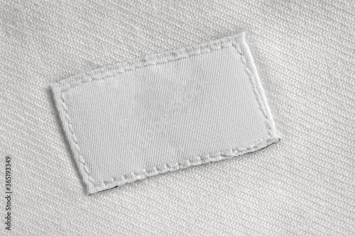 White blank laundry care clothes label on cotton shirt background