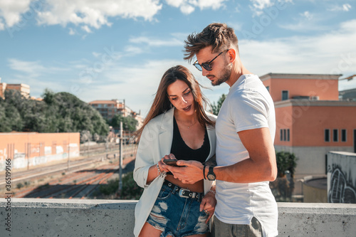 Photos Giovani fidanzati guardano insieme con attenzione le notifiche del loro telefono