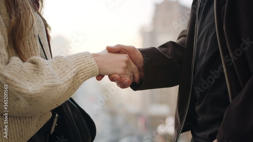 Fotografia Unrecognizable couple handshaking outside