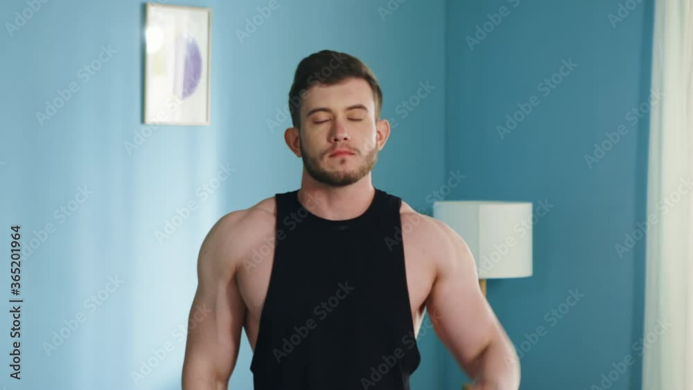 Young athletic man is doing morning exercise, warming up at home, stretching his neck, starts working day actively, enjoying his lifestyle and sport, Close up, Slow motion.