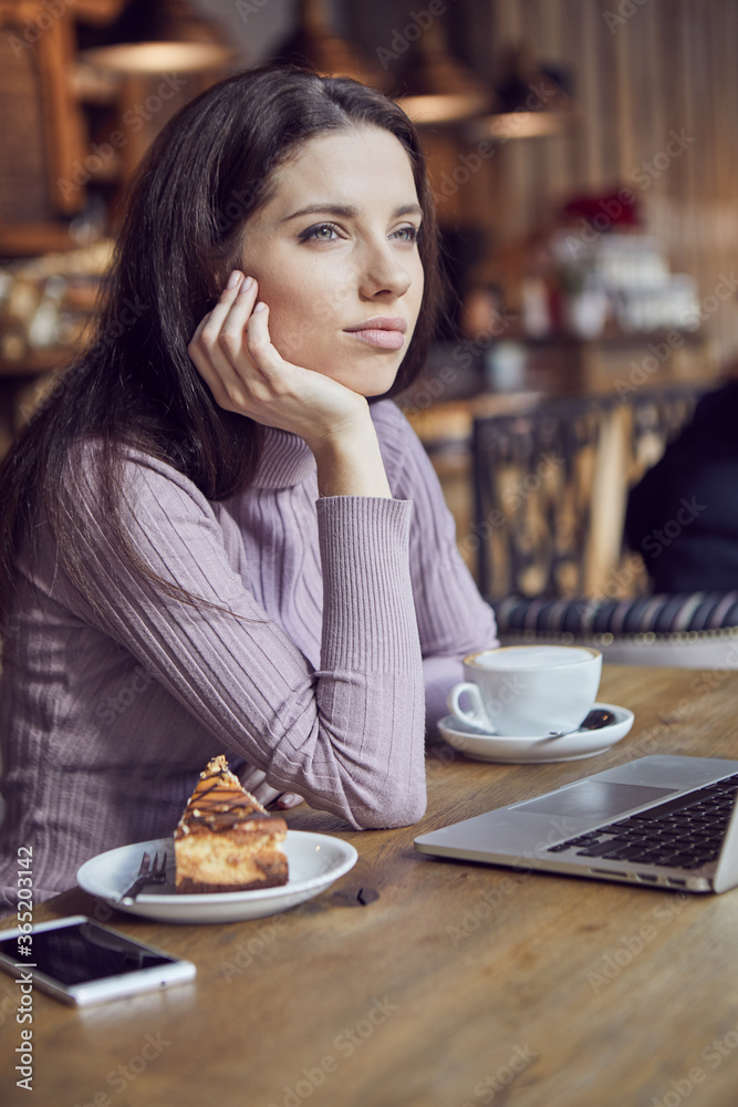 Woman works remotely online from cafe while quarantine coronavirus is in effect. Concept of checking mail, blogger, freelancer