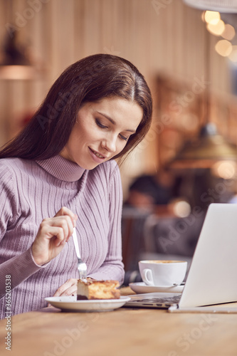 Woman works remotely online from cafe while quarantine coronavirus is in effect. Concept of checking mail  blogger  freelancer