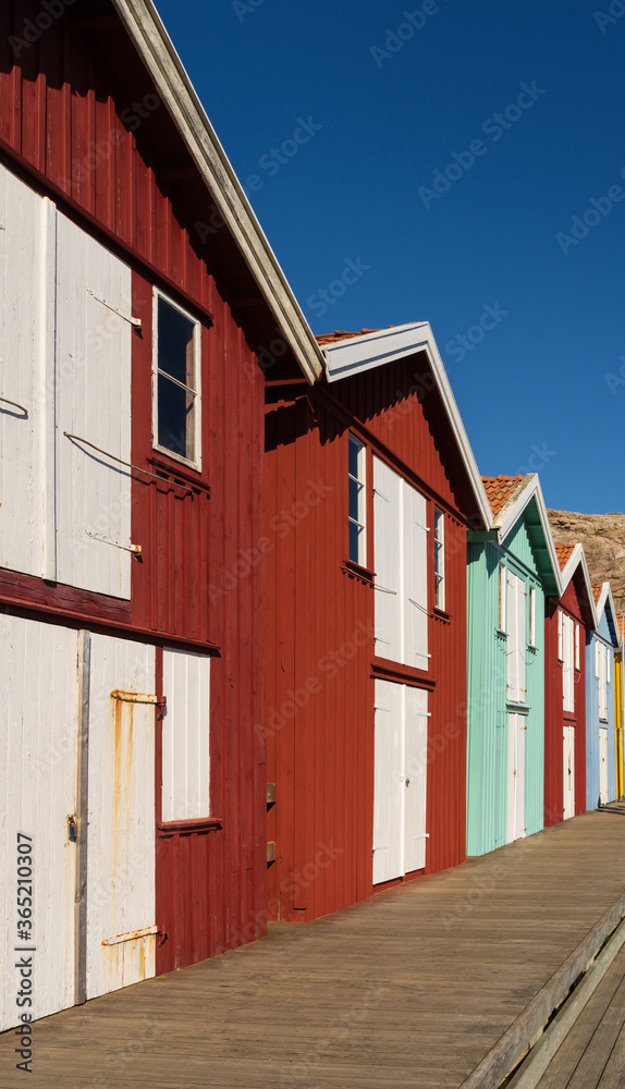 Colorful boathouses in row on the island of Smogen in Sweden. This is a popular tourist destination during summer season.