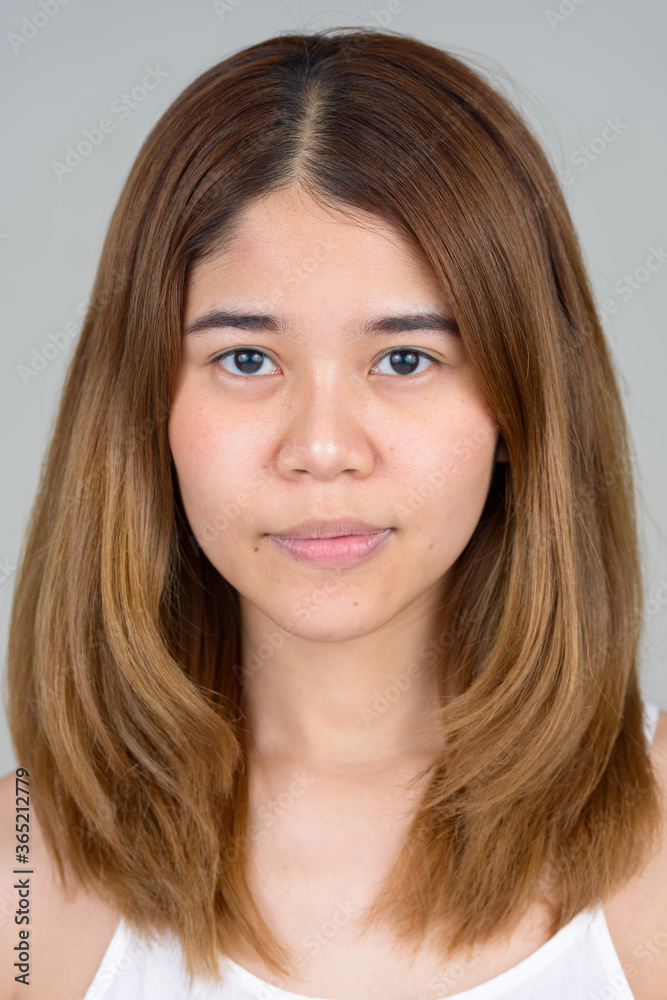 Portrait of young Asian woman against white background Portrait of young Asian woman against white background