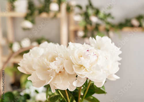 Floral background. Flower shop interior. Floral design studio, making decorations and arrangements. Flowers delivery service and sale of home plant, creating order. Peonies and roses. © Aleksandr