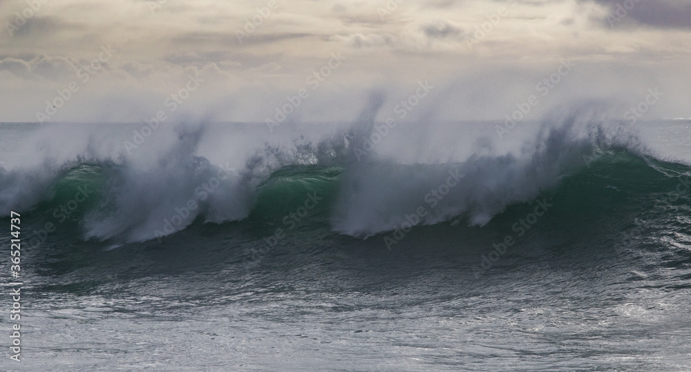 vague énorme déferlant sur la côte pendant la tempête