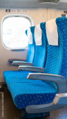 A row of empty Commuter Train in Japan High-Speed Rail. Three blue armchairs with no passengers due to COVID-19  restrictions affects the travel industry. (ID: 365216967)
