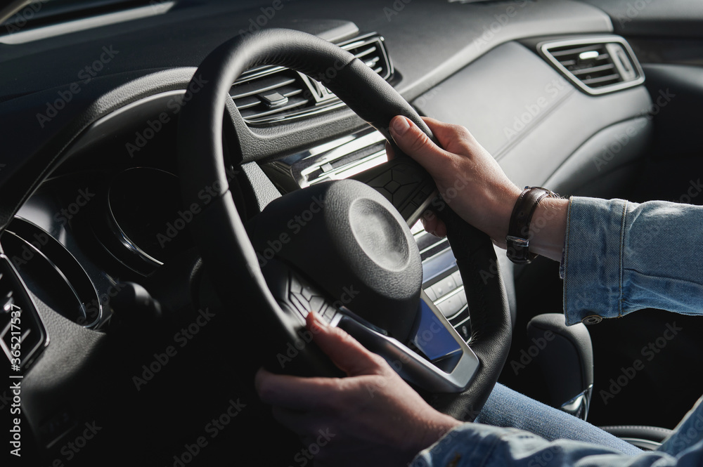 Man hold hands on car steering wheel