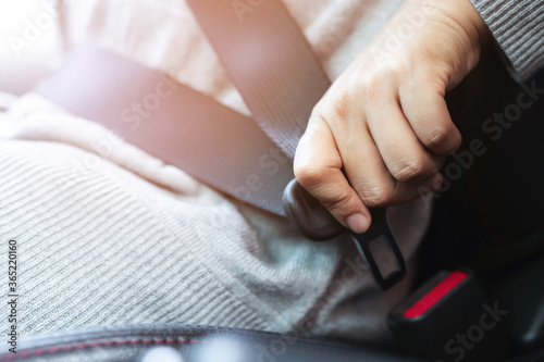 Close Up of people woman hand fastening seat safety belt in car for safety before driving on the road. concept transport travel. soft focus.