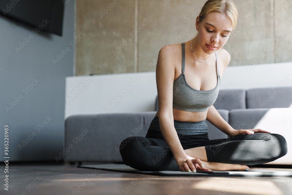 Photo of focused beautiful woman using mobile phone while working out