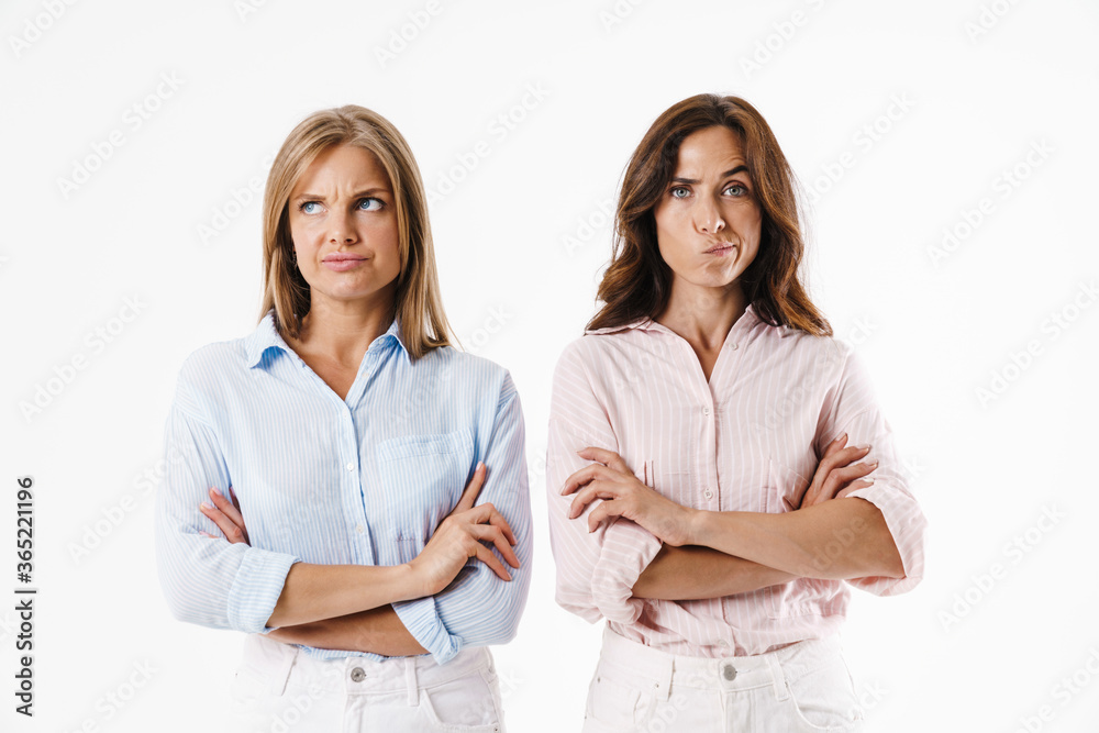 Image of displeased two women posing with hands crossed on camera Image of displeased two women posing with hands crossed on camera