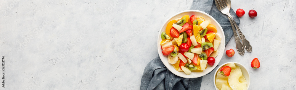 Fresh chopped fruit salad in a bowl. Long banner format.