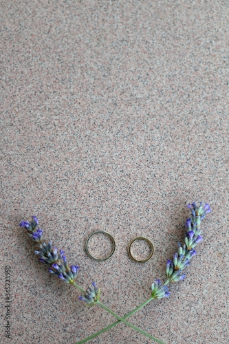 Gold wedding rings and lavender flowers. Top view. 