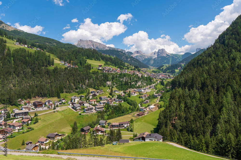 The stunning Alpine village of Ortisei with blue sky and white fluffy clouds, an awesome view of the majestic Dolomites, Northern Italy, Europe