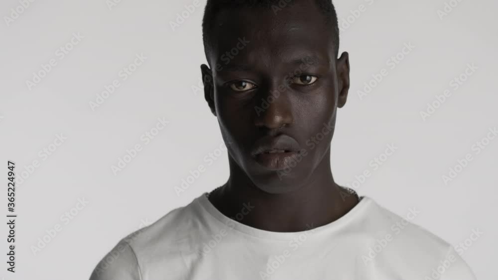 Close up handsome confident African American man aggressively looking in camera over gray background. Serious expression Close up handsome confident African American man aggressively looking in camera over gray background. Serious expression