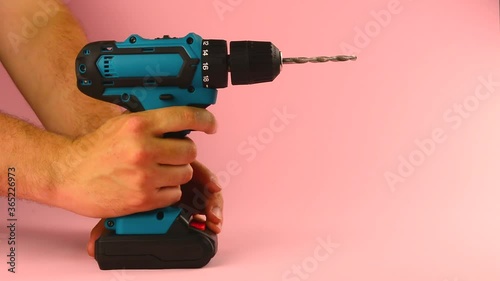 electric drill with a drill on a pink background