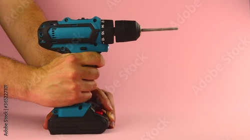 electric drill with a drill on a pink background