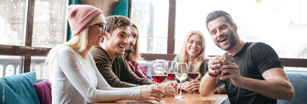Smiling friends in cafe drinking alcohol and make a selfie. Smiling friends in cafe drinking alcohol and make a selfie.