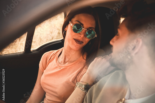 Primo piano di coppia di giovani fidanzati mentre si guardano con amorevole complicità dentro la loro automobile photo