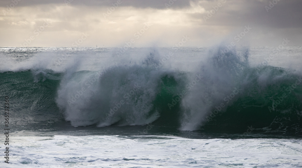 panoramique d'une vague énorme pendant une tempête le matin