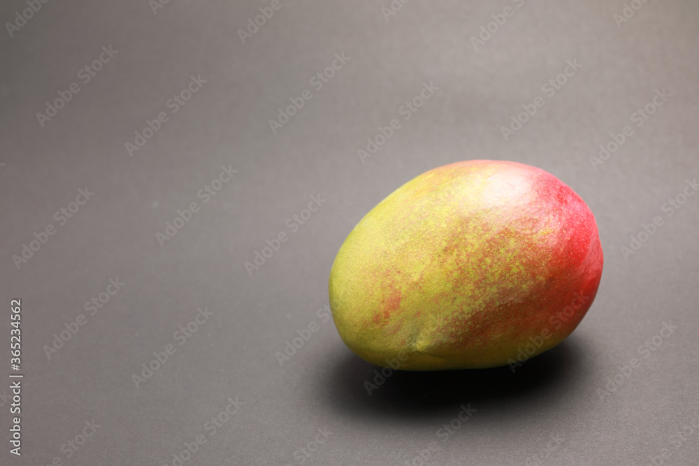 close up view of one fresh mango isolated on gray background close up view of one fresh mango isolated on gray background