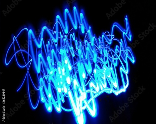 Light painting design. Combination of sky blue and white light against a black background 