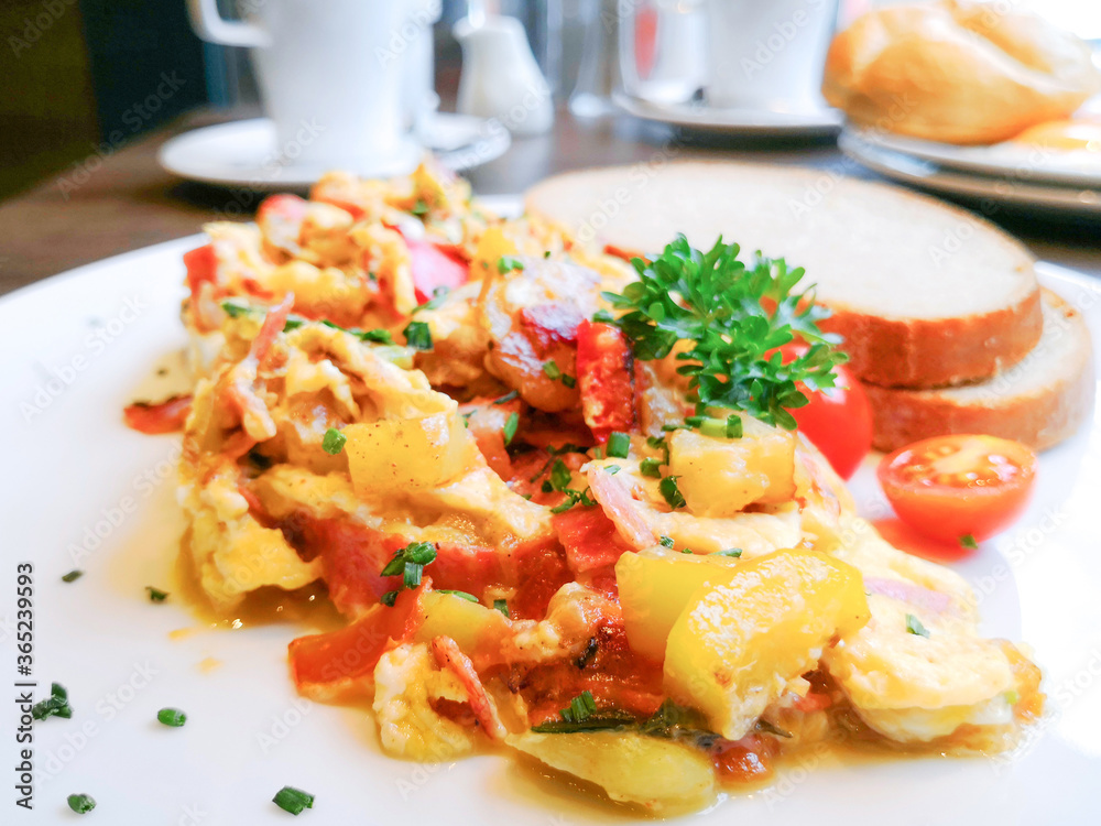 Omelet cooked with tomatoes and chives prepared with fresh lettuce as side dishes for an healthy vegetarian breakfast ready to be served Omelet cooked with tomatoes and chives prepared with fresh lettuce as side dishes for an healthy vegetarian breakfast ready to be served