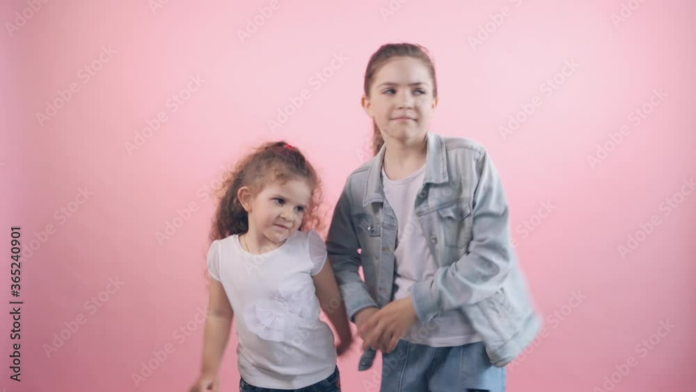 Two beautiful cute girls sisters having fun and dancing to the music. Two beautiful cute girls sisters having fun and dancing to the music.