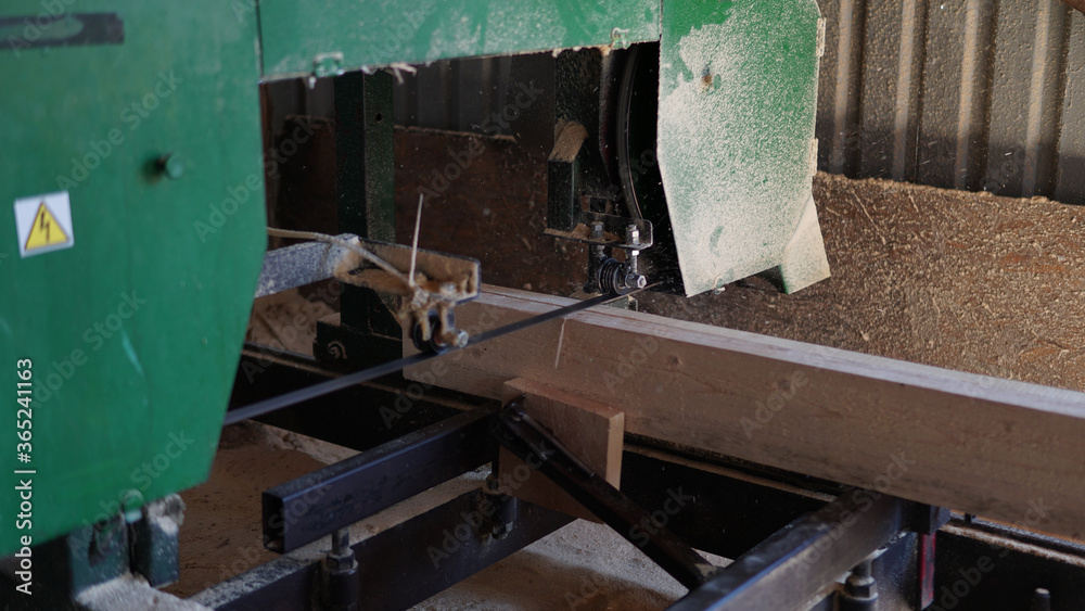 An old woodworking machine cuts the board An old woodworking machine cuts the board
