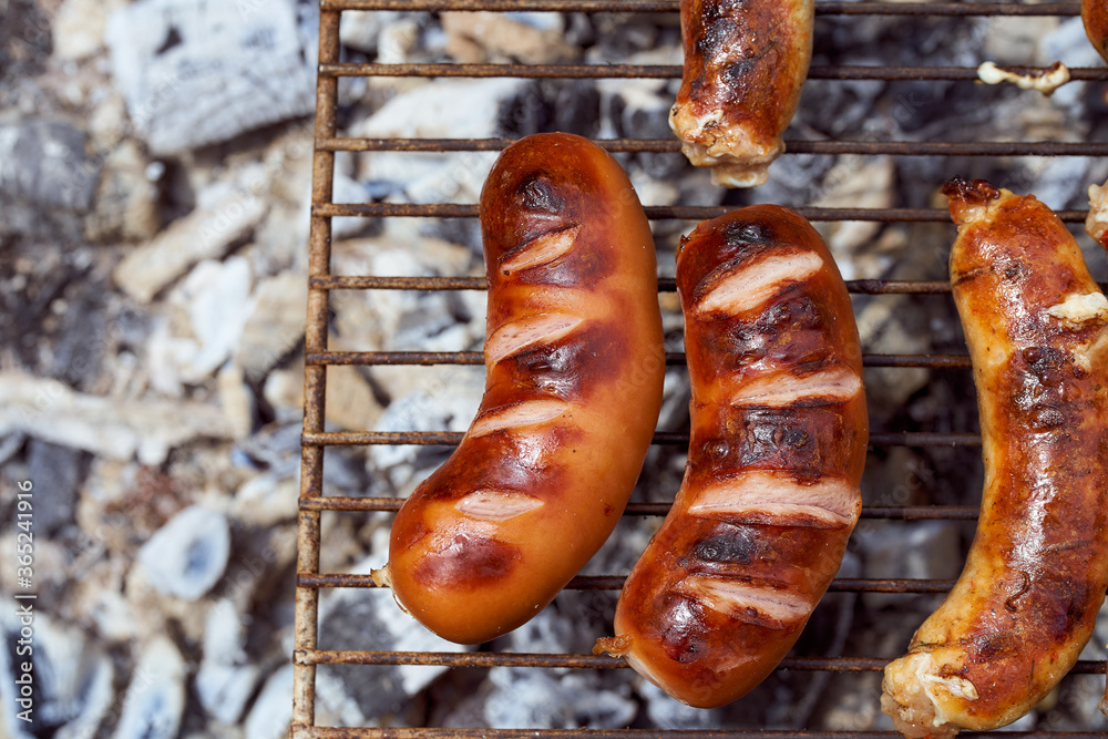Homemade grilled meat sausages lie on the grill. Close-up. Homemade grilled meat sausages lie on the grill. Close-up.