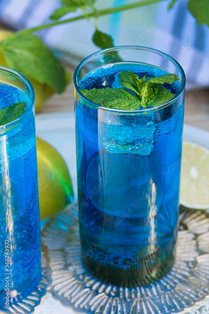 Blue Curacao refreshing drink with lime and lemon slices, garnished with fresh mint leaves. Blue Curacao refreshing drink with lime and lemon slices, garnished with fresh mint leaves.