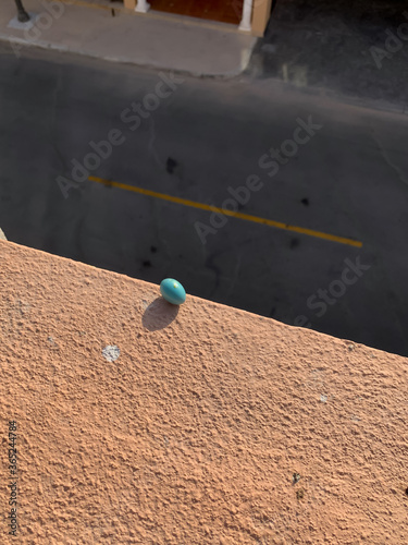 Fototapeta Naklejka Na Ścianę i Meble -  Turquoise egg teetering on edge of ledge 