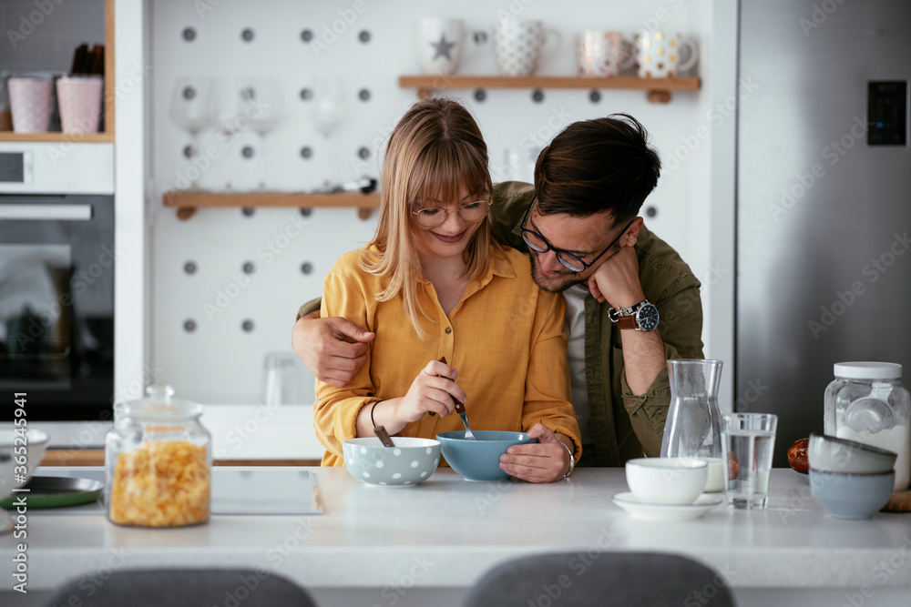 Happy couple eating breakfast at home. Husband and wife enjoying in the morning.	