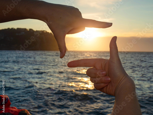 Fényképezés Framing sun above sea. Hands making frame