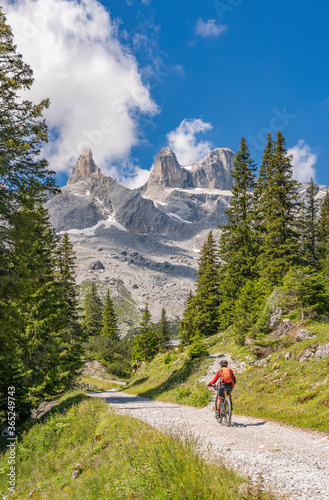 senior woman riding her electric mountain bike up to the Lindau Hut below the famous summits of Drusenfluh and Three towers in the Montafon Area of Vorarlberg Austria